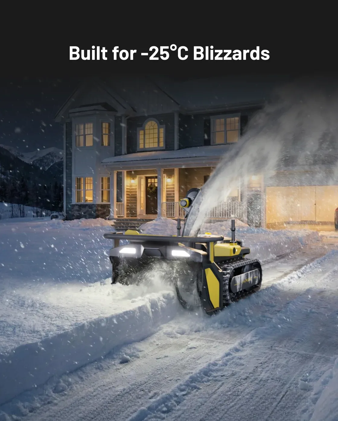 The robot clearing a driveway at night in heavy blizzard snowfall in front of a lit house